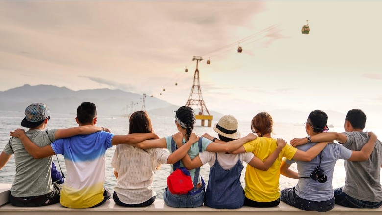Groupe d'amis, bras enlacés, regardant l'horizon